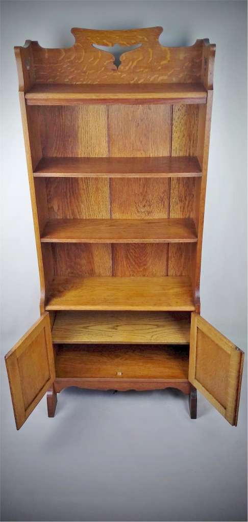 Arts and crafts bookcase with bird motif , golden oak