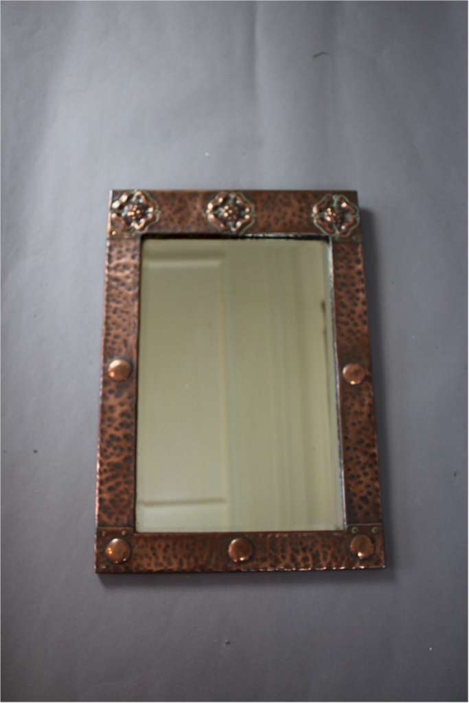 Arts and Crafts copper framed wall mirror with three stylised flower