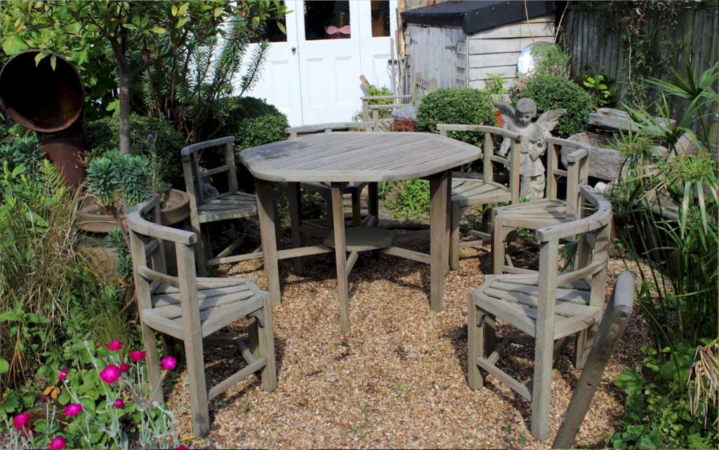 Rare teak garden set of table and six wrap round chairs retailed by