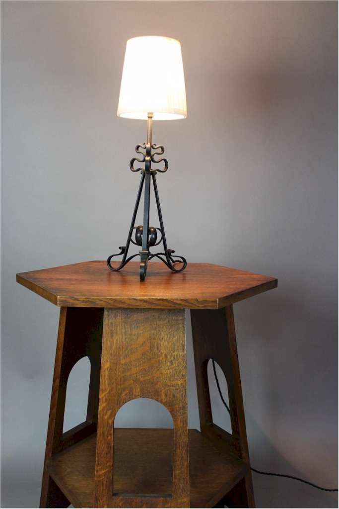 Arts and crafts iron table lamp with scrolling supports c1900