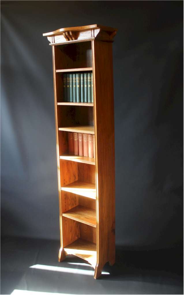 Tall Arts and Crafts oak open bookcase with shaped top
